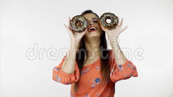 快乐的现代女人微笑着玩着休闲服装的甜甜圈休闲概念视频的预览图
