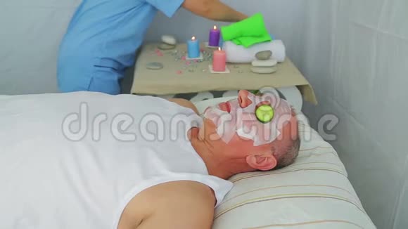 一位女性美容师在法力的脸上做蔬菜疗法视频的预览图