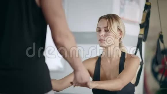 微笑健身女子手握私人教练手在健身房俱乐部视频的预览图