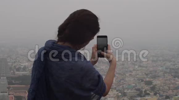 年轻女性在电话室外复制文本空间拍摄雾蒙蒙的城市景观照片无法辨认的深色头发视频的预览图