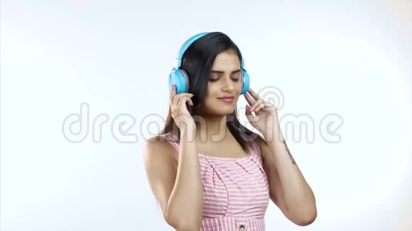 微笑印度女人听音乐享受生活方式白色背景视频的预览图