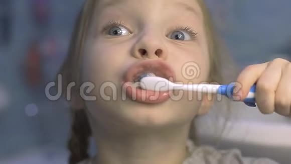 小女孩早上在浴室里用牙刷刷牙视频的预览图