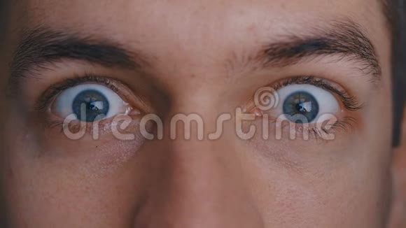 特写宏观美男蓝眼睛描绘恐惧和惊喜视频的预览图
