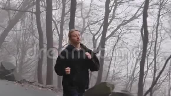 在雾中穿过森林的女人视频的预览图