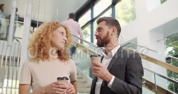 男女办公室工作人员站立交谈休息时喝咖啡企业家谈话和谈话视频的预览图