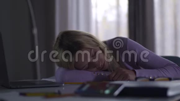 年轻的金发白种人女人睡在办公室的桌子上她的手机响在前台年轻疲惫视频的预览图