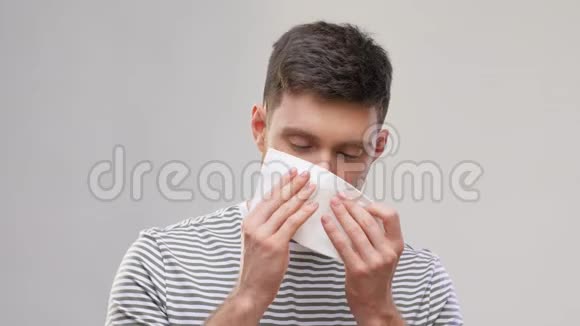 有病的年轻人用纸巾擤鼻涕视频的预览图