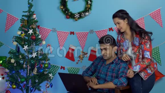 快乐的印度夫妇在圣诞前夜一起用笔记本电脑做视频通话视频的预览图