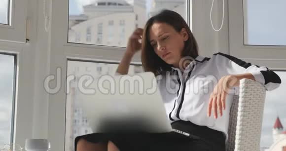 自信的女性职业人士穿着白色上衣在笔记本电脑上工作打电子邮件在大城市的现代办公室工作视频的预览图