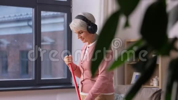 戴着扫把的耳机的老妇人视频的预览图