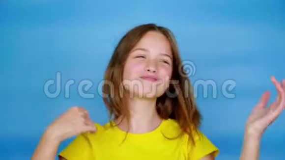 穿着黄色T恤的快乐少女正在跳舞微笑着到处是傻瓜视频的预览图
