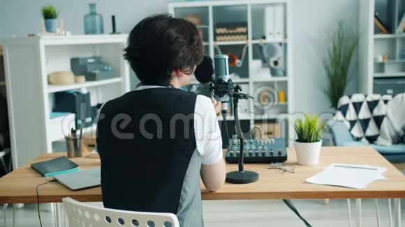 青少年录音播客在录音室用麦克风交谈的背面视图视频的预览图