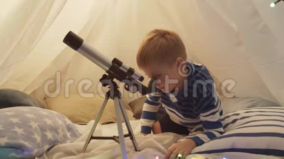 小男孩在家里的儿童帐篷里玩望远镜快乐的白种人小孩在游戏室视频的预览图