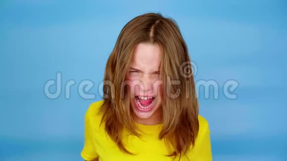 一个穿着黄色T恤的愤怒少女在尖叫看着镜头鬼脸视频的预览图