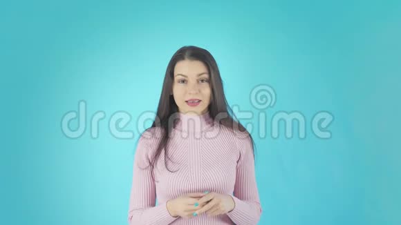 年轻的震惊女人站在蓝色背景下看镜头视频的预览图