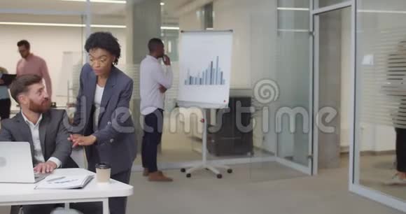 一群多民族的工人兴高采烈地站在办公室里妇女和男子办公室工作人员会议视频的预览图
