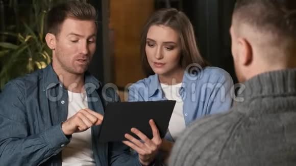夫妇看着平板电脑NHoosing做出了决定一个年轻的家庭购买在一个金融会议上视频的预览图