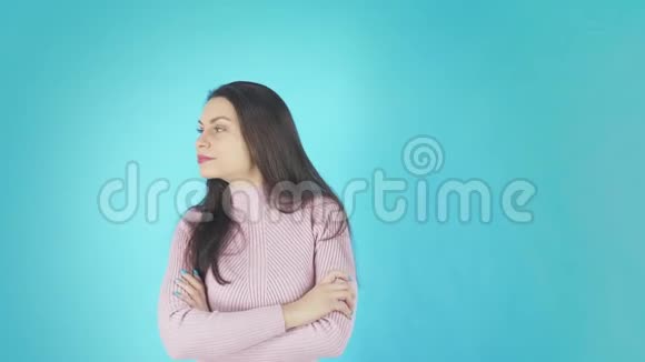 年轻的震惊女人站在蓝色背景下看镜头视频的预览图
