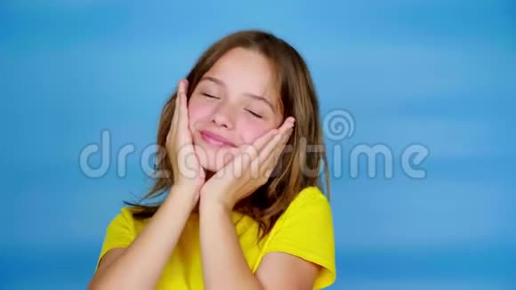身穿黄色t恤的快乐少女张开双手微笑着摆姿势看着镜头视频的预览图