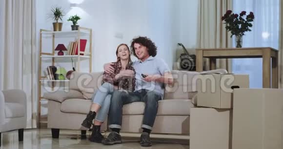 一对笑容可掬魅力非凡的年轻夫妇在一所新房子里享受时光搬家一天后他们还带着着箱子视频的预览图