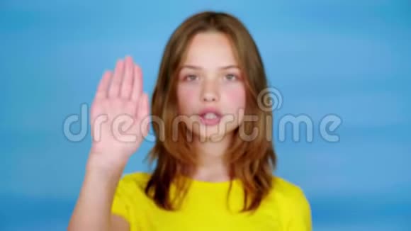 穿黄色T恤的少女看着镜头伸出手在前面说停视频的预览图