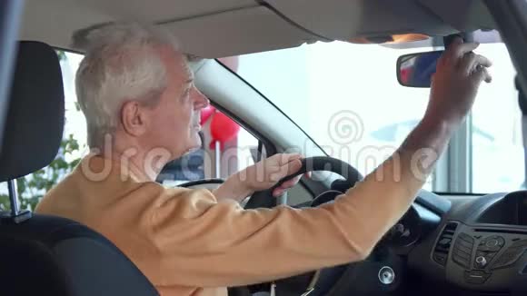 老人调整车内后视镜视频的预览图