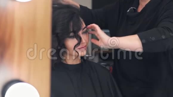 坐在镜子对面的专业美容院做发型的时髦年轻女子视频的预览图