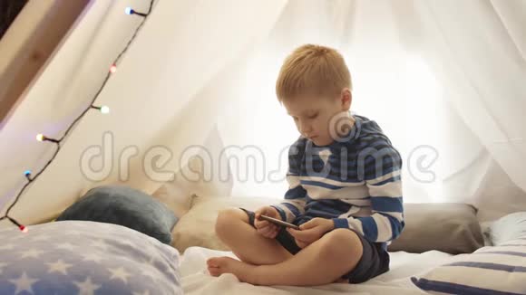 小男孩在家里的儿童帐篷里玩游戏室里快乐的白人孩子视频的预览图