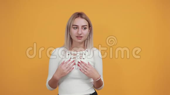年轻的金发女人面部表情惊讶双手放在脸颊上视频的预览图
