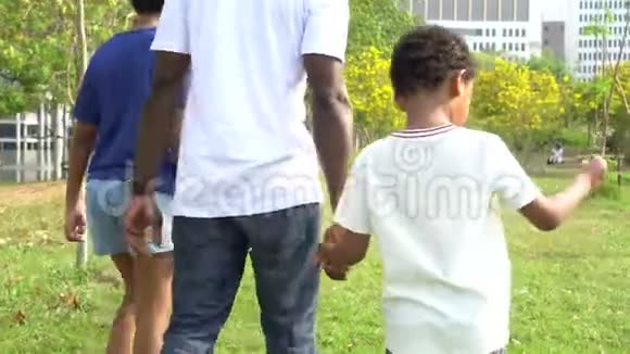 非裔美国人的父亲在大自然中与十几岁的女儿散步与儿子牵手娱乐家庭视频的预览图