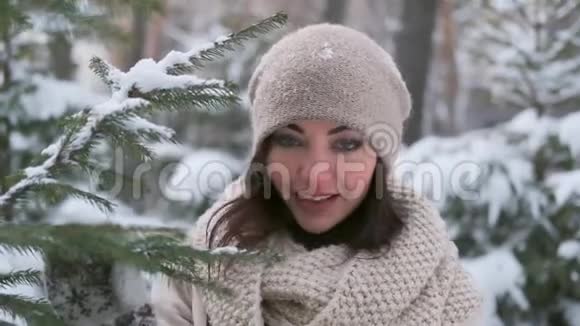 圣诞树附近一个冬天公园里一个美丽的年轻女孩的肖像慢动作视频的预览图