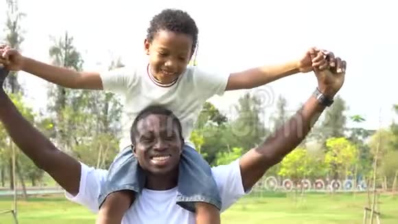 快乐的非裔美国人父子捎带在户外公园家庭周末活动视频的预览图