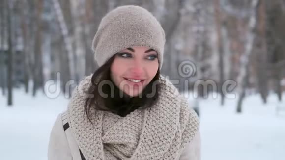 迷人的蓝眼睛年轻女子走过冬林环顾四周微笑着特写视频的预览图