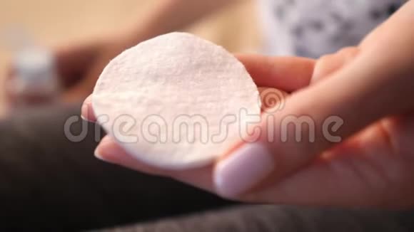 皮肤护理一个女人在棉垫上倒一个清洁补品特写视频的预览图