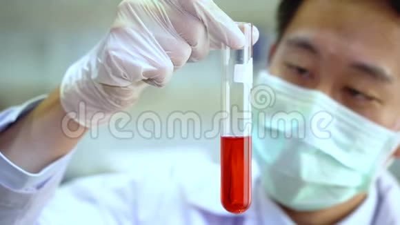 亚洲男性科学家的特写镜头白色均匀的实验室瓶与红色化学溶液化学视频的预览图