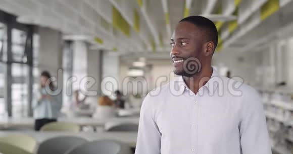 穿着衬衫的非洲男老板转头对着镜头微笑30岁的男队长心情好站在视频的预览图