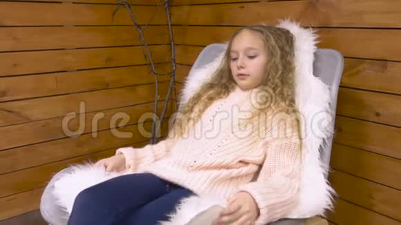坐在舒适椅子上的小女孩视频的预览图