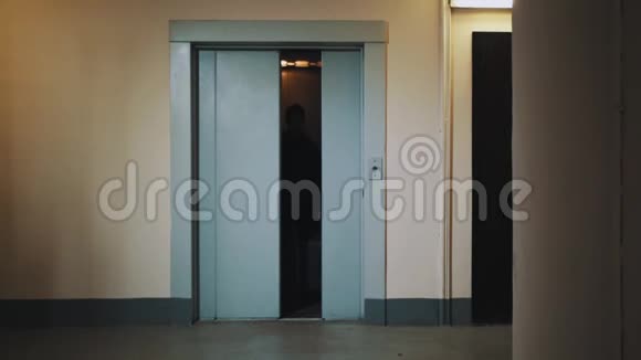 宿舍走廊带行李箱走出电梯的男子视频的预览图