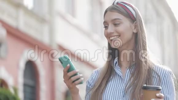 漂亮的女人在街上收到好消息快乐的女人在户外留言读好消息兴奋的女孩视频的预览图