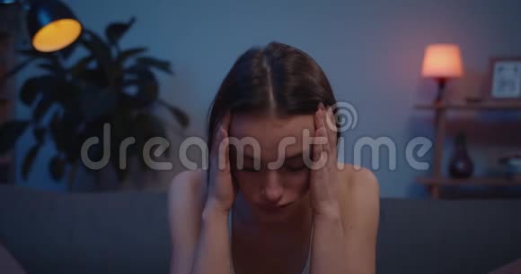 紧紧地抱着一个年轻的心烦意乱的女孩哭着用手抱着头沮丧的女人坐在沙发上泪流满面视频的预览图
