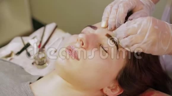美容师从顾客的眉毛上洗指甲花并涂上一种特殊的奶油视频的预览图