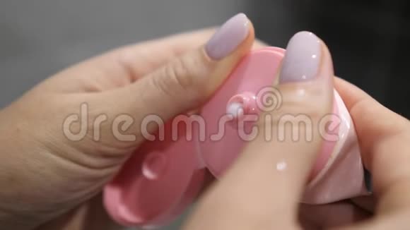 女用手捏浴室里管子里的泡沫化妆面部卫生护肤霜特写朝鲜视频的预览图