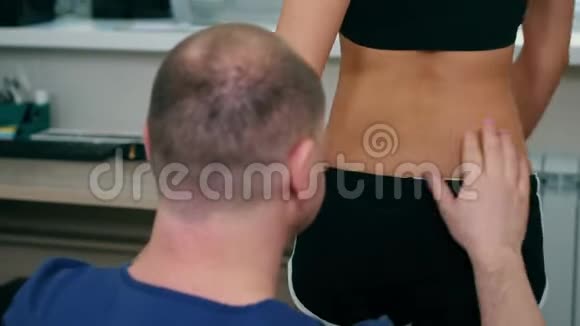 脊椎按摩治疗医生在柜子里处理年轻妇女的背部和颈部一名妇女转向视频的预览图