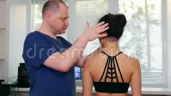 脊椎按摩治疗医生将年轻女性的颈部向两侧移动视频的预览图