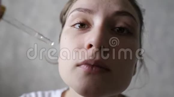 美容和个人护理一个健康的女人用吸管把血清涂在脸上天然化妆品视频的预览图