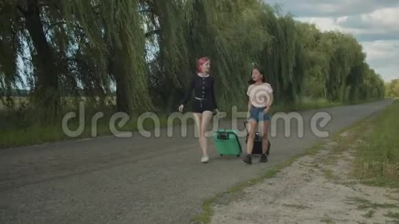 带着旅行袋的女游客走在农村公路上视频的预览图