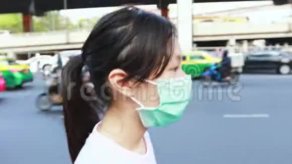 疲惫的亚洲女孩打喷嚏咳嗽戴卫生口罩空气污染问题呼吸道疾病空气污染吸入视频的预览图