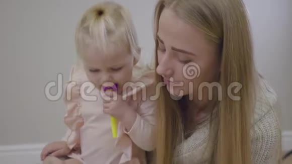 年轻白种人母亲和女婴的特写女人和她可爱的金发小女儿说话抱着孩子视频的预览图