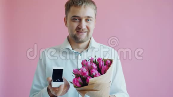 一个长着胡子的帅哥戴着一束鲜花和订婚戒指的肖像视频的预览图