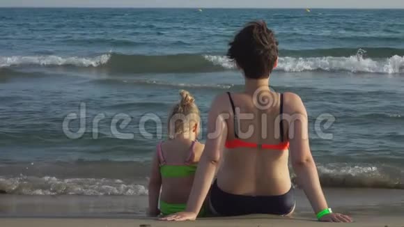 妈妈和女儿在海边坐得很近视频的预览图